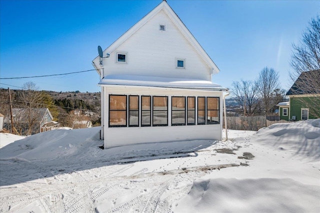 snow covered property with a sunroom