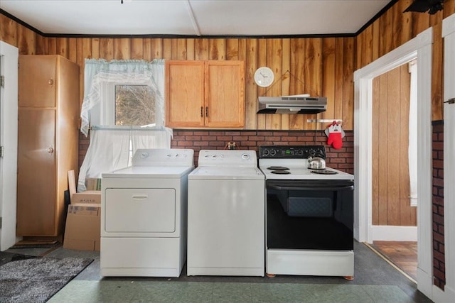 laundry area featuring laundry area, washer and clothes dryer, and wood walls