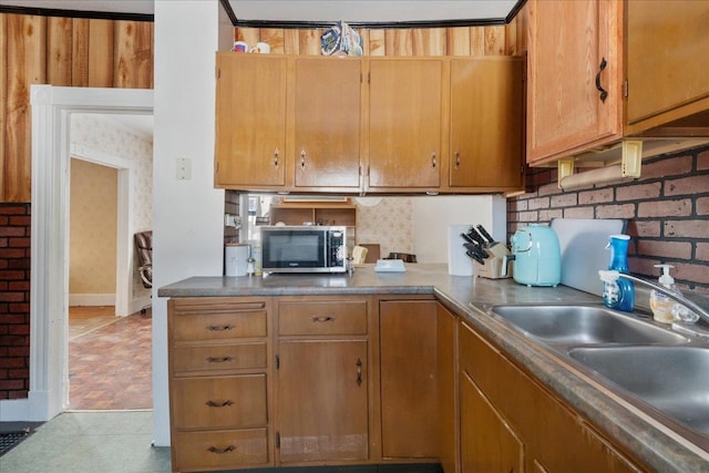 kitchen featuring stainless steel microwave, backsplash, and a sink