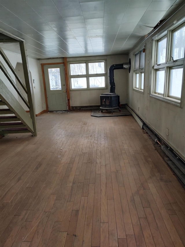 interior space featuring a wood stove, stairway, and wood finished floors