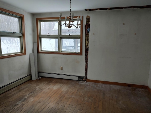 unfurnished room with baseboards, a baseboard radiator, a chandelier, and hardwood / wood-style floors