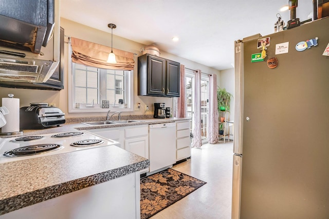 kitchen with a sink, hanging light fixtures, freestanding refrigerator, dishwasher, and light floors