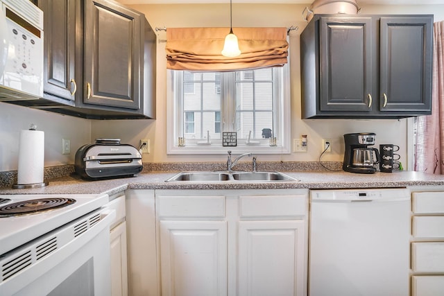 kitchen with hanging light fixtures, white appliances, white cabinets, and a sink