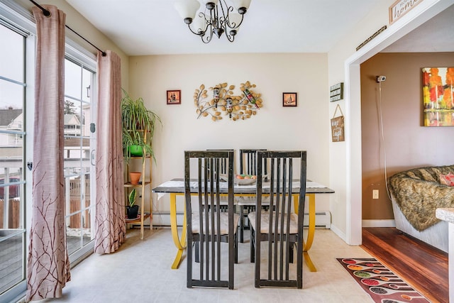 dining area with an inviting chandelier, baseboards, and a baseboard heating unit