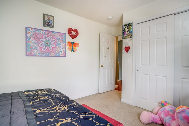 carpeted bedroom with baseboards and a closet