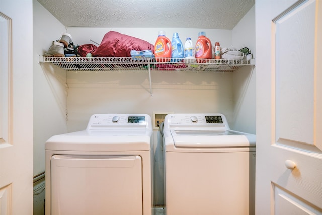 washroom featuring laundry area, a textured ceiling, and washing machine and clothes dryer