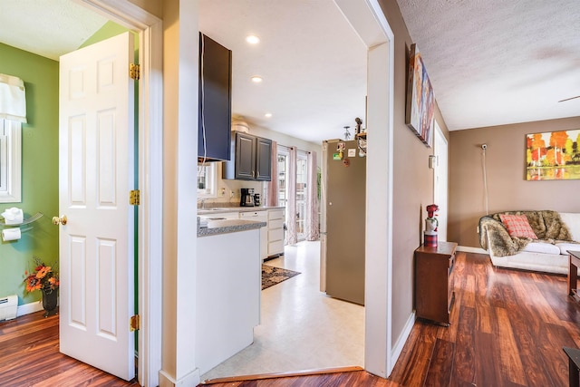 hallway with recessed lighting, light wood finished floors, and baseboards