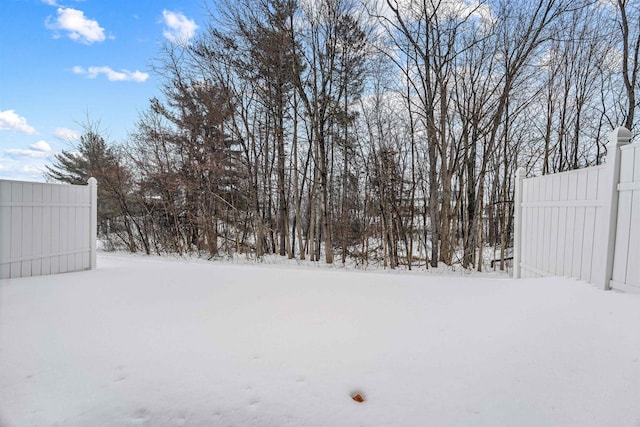 yard covered in snow with fence