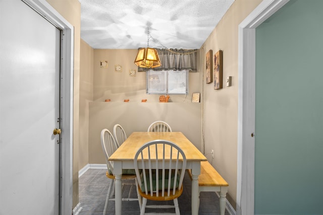 dining room with a textured ceiling and baseboards