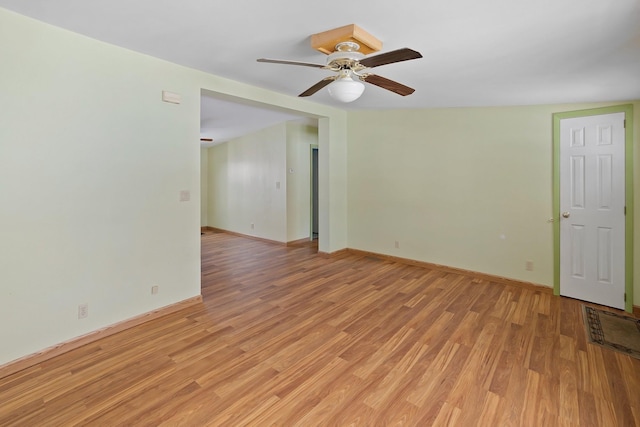 unfurnished room with light wood finished floors, a ceiling fan, and baseboards