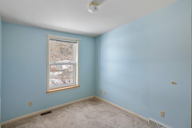 unfurnished room featuring carpet, visible vents, and baseboards