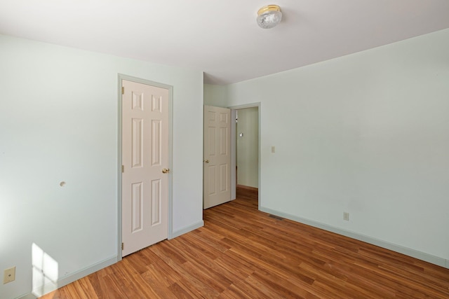 unfurnished bedroom featuring light wood-type flooring and baseboards