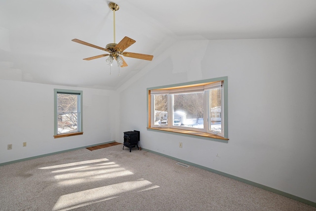 unfurnished room with lofted ceiling, carpet, visible vents, and baseboards