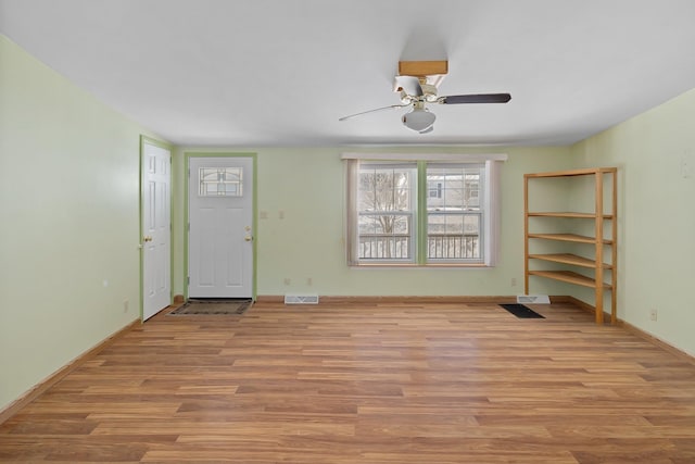 foyer entrance featuring visible vents, ceiling fan, light wood-style flooring, and baseboards