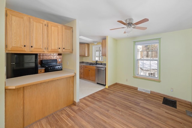 kitchen with black appliances, light brown cabinets, visible vents, and a sink