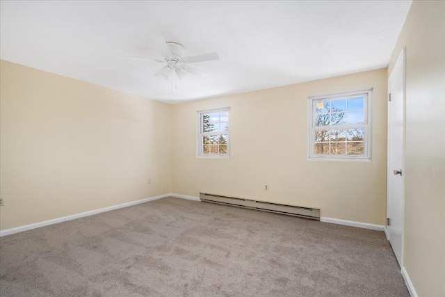 carpeted spare room featuring a baseboard heating unit, a healthy amount of sunlight, ceiling fan, and baseboards