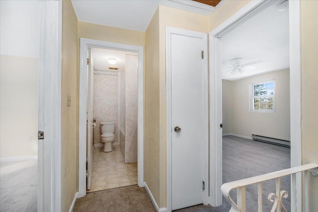 hallway with carpet and a baseboard heating unit