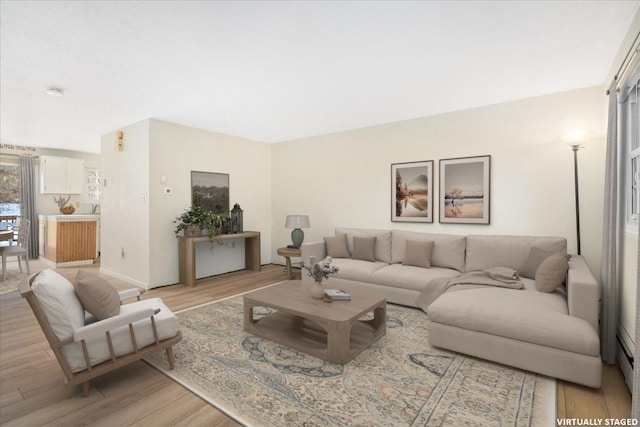 living area featuring baseboards and light wood-style floors