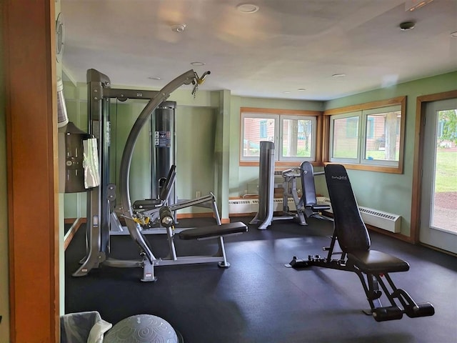 workout room with a baseboard radiator, baseboards, and a wealth of natural light