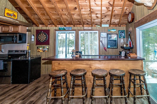 bar featuring wooden walls, appliances with stainless steel finishes, wood finished floors, and vaulted ceiling with beams