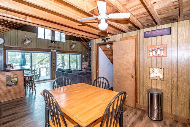 dining area with wooden walls, wood ceiling, wood finished floors, and vaulted ceiling with beams