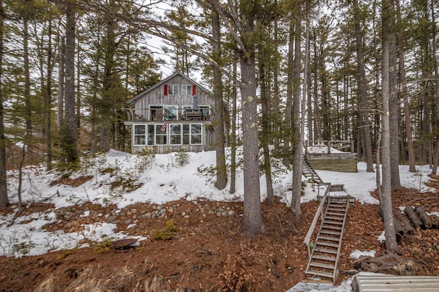 exterior space with board and batten siding, stairs, and a sunroom