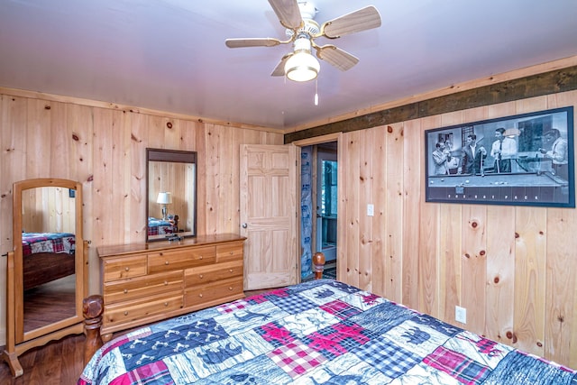 bedroom with ceiling fan, wood finished floors, and wood walls