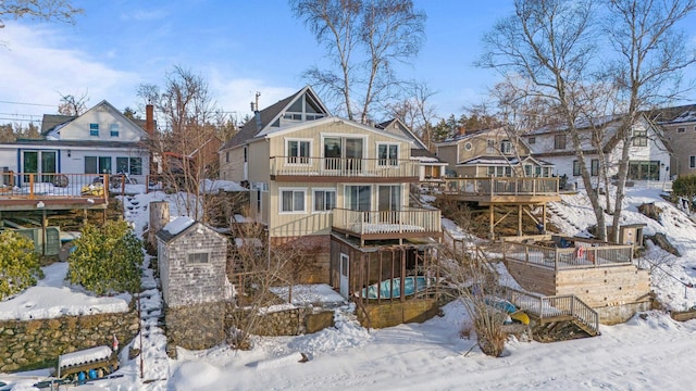 snow covered house with board and batten siding, a residential view, and stairway