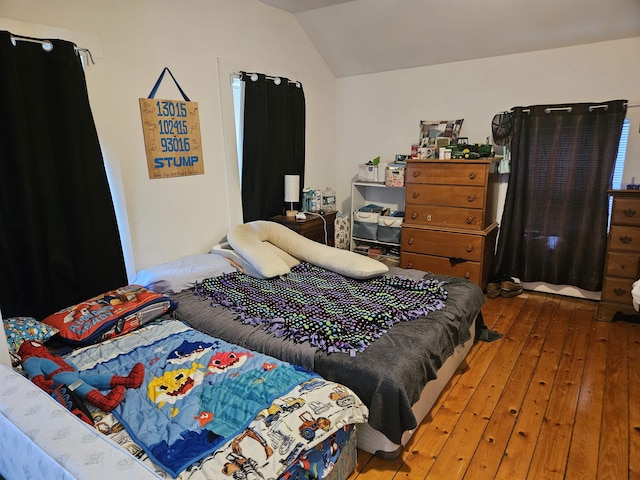 bedroom with lofted ceiling and wood-type flooring