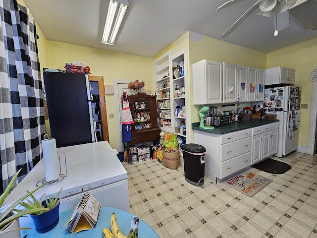 kitchen featuring white cabinets, range, light floors, and ceiling fan