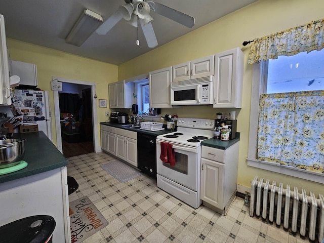 kitchen featuring light floors, dark countertops, white appliances, and radiator heating unit