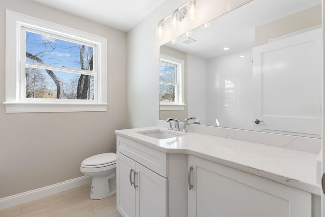 bathroom featuring toilet, baseboards, and vanity