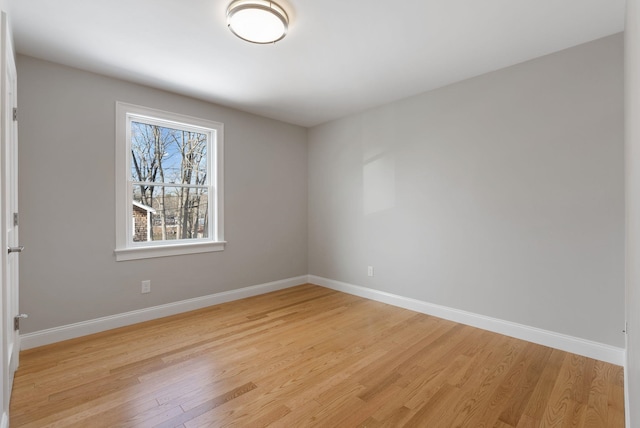 empty room featuring baseboards and light wood finished floors