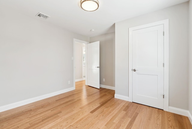 unfurnished bedroom featuring light wood finished floors, visible vents, and baseboards