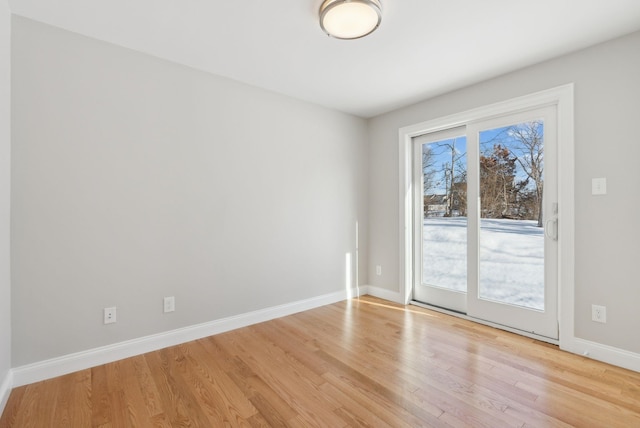 spare room with light wood-style flooring and baseboards