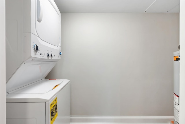 clothes washing area featuring stacked washer and dryer and laundry area