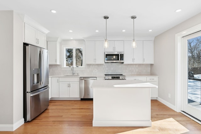 kitchen with white cabinetry, appliances with stainless steel finishes, light countertops, and a sink