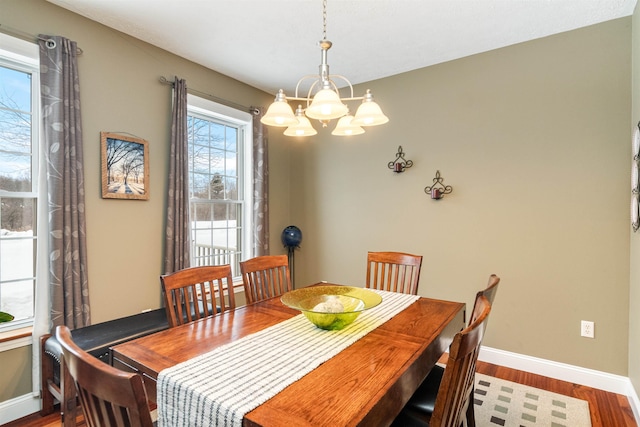 dining room featuring baseboards, a chandelier, and wood finished floors