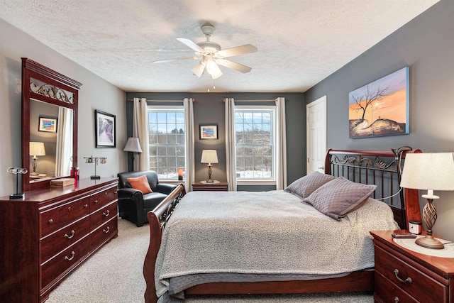 bedroom featuring carpet floors, a textured ceiling, and a ceiling fan