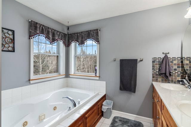 bathroom with baseboards, tile patterned flooring, a tub with jets, and a sink