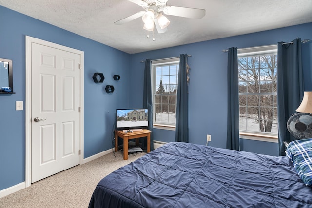 bedroom featuring multiple windows, baseboards, a textured ceiling, and carpet flooring