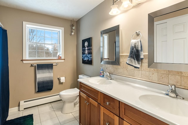 bathroom featuring toilet, a sink, baseboard heating, and tile patterned floors