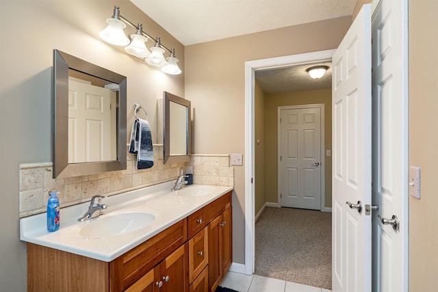 full bathroom with double vanity, tasteful backsplash, a textured ceiling, and a sink