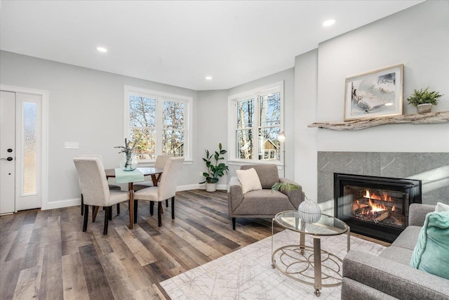 living area with baseboards, a tiled fireplace, wood finished floors, and recessed lighting