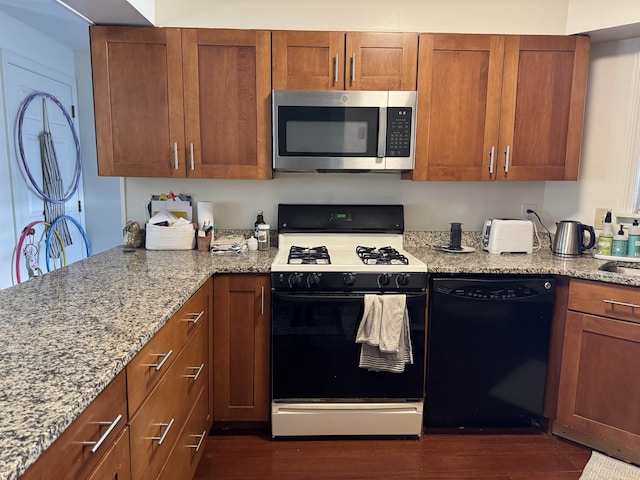 kitchen featuring black dishwasher, brown cabinetry, range with gas cooktop, stainless steel microwave, and light stone counters