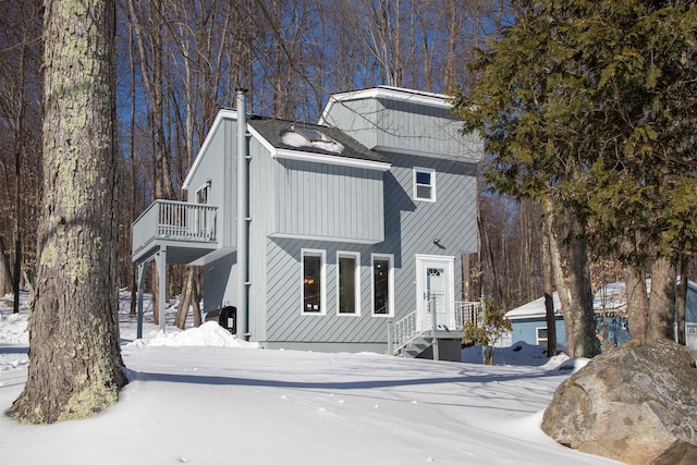 view of front of home featuring a chimney and a balcony