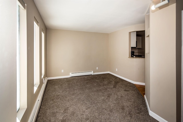 empty room featuring a baseboard heating unit, dark colored carpet, baseboards, and baseboard heating