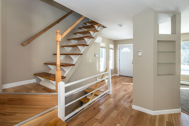 entryway featuring stairs, baseboards, and wood finished floors