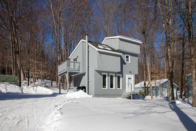 view of front of home with a chimney and a balcony