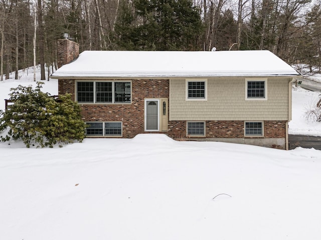 split foyer home featuring a chimney and brick siding